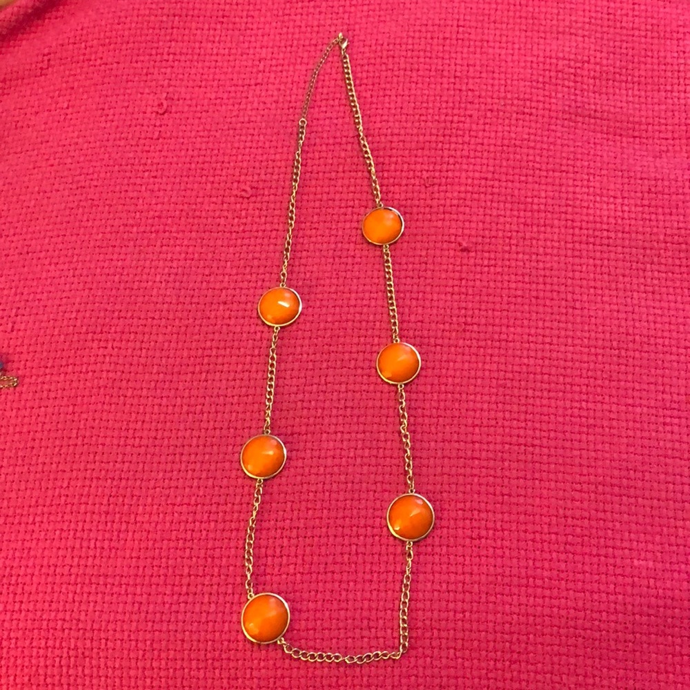 Gold long necklace with orange charms.